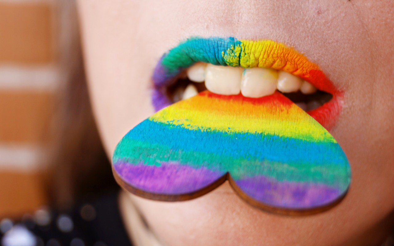 Person Biting Multicolored Heart Decor