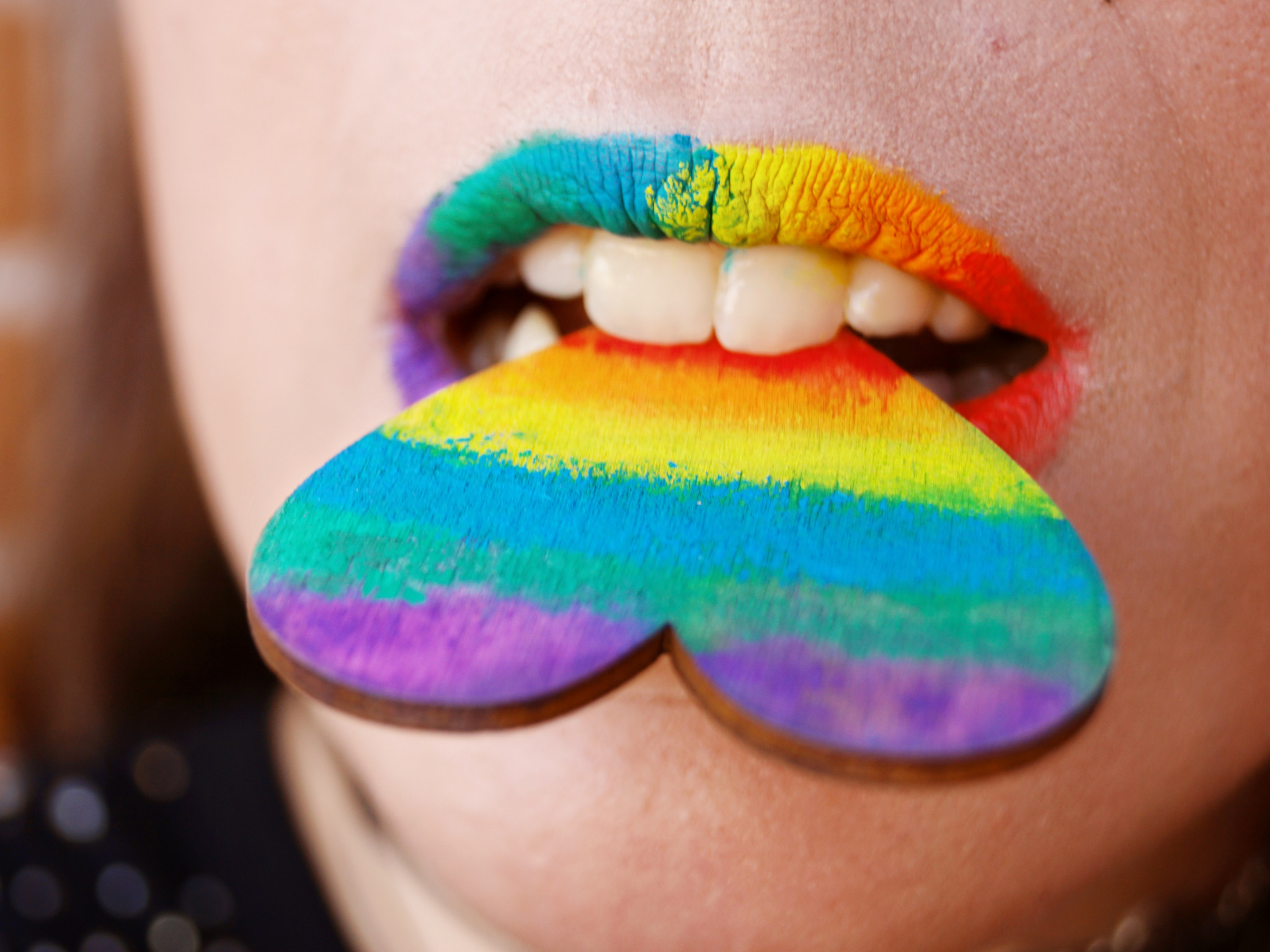 Person Biting Multicolored Heart Decor