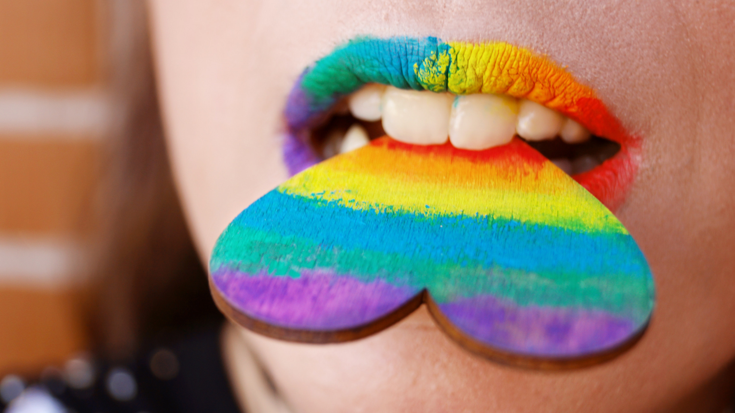 Person Biting Multicolored Heart Decor