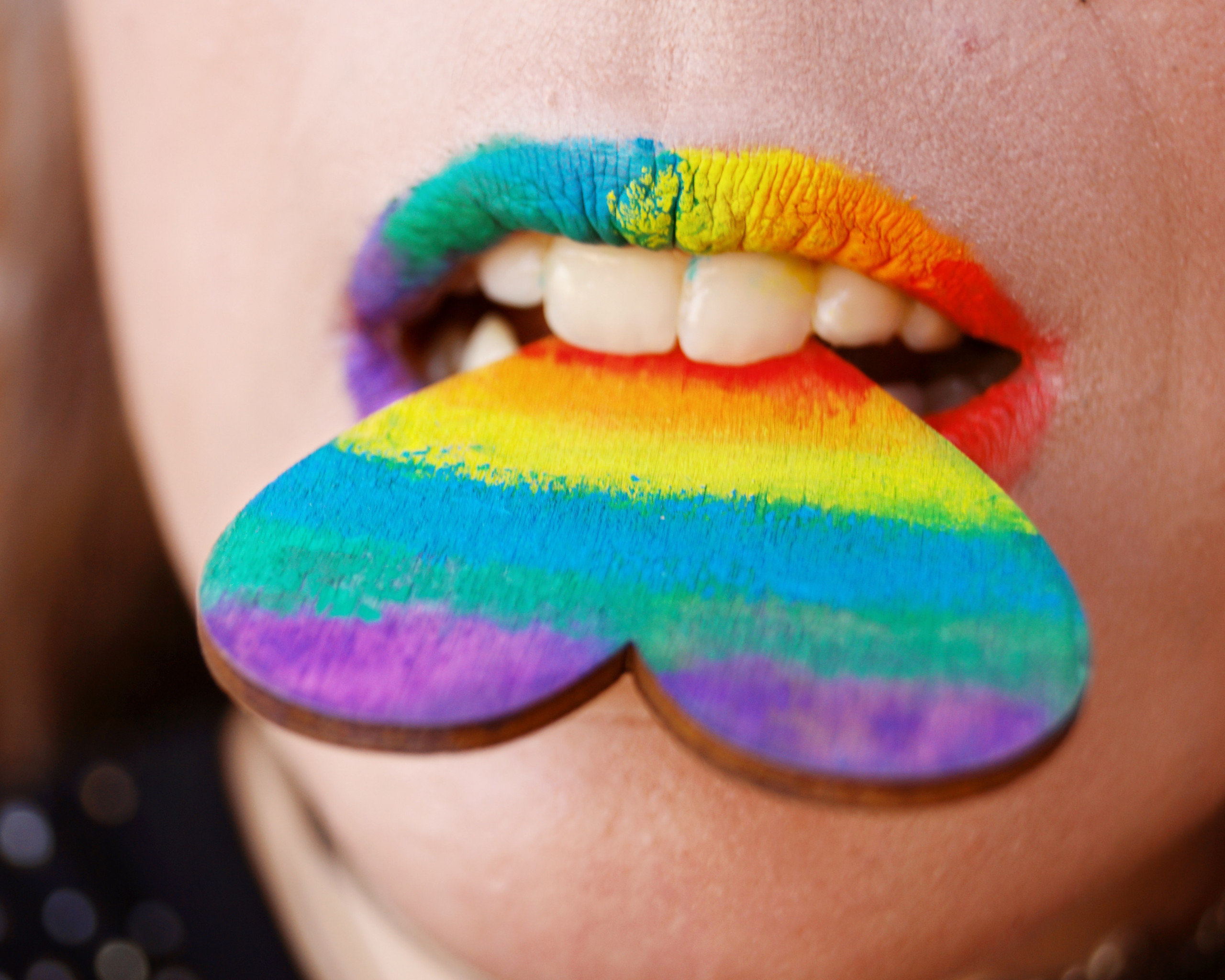 Person Biting Multicolored Heart Decor