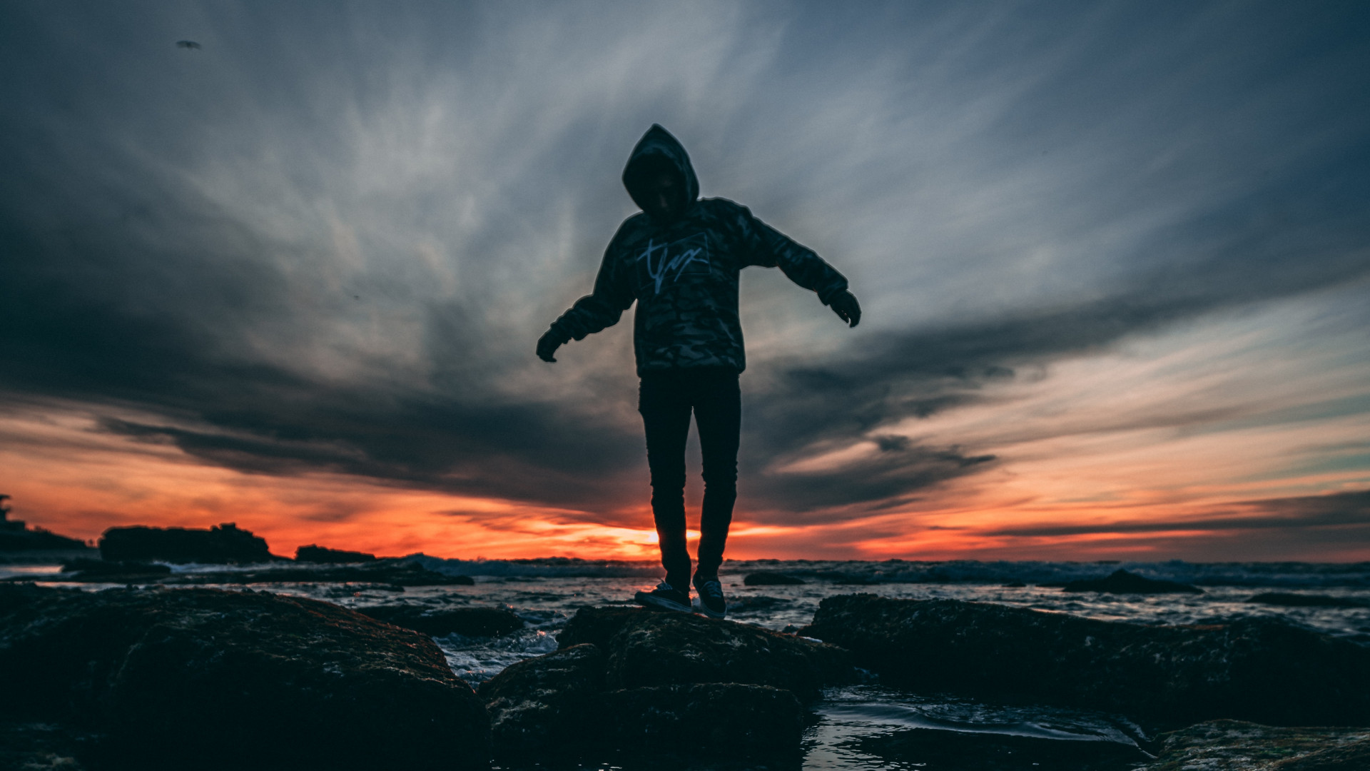 Person Wearing Hoodie Standing on Rock