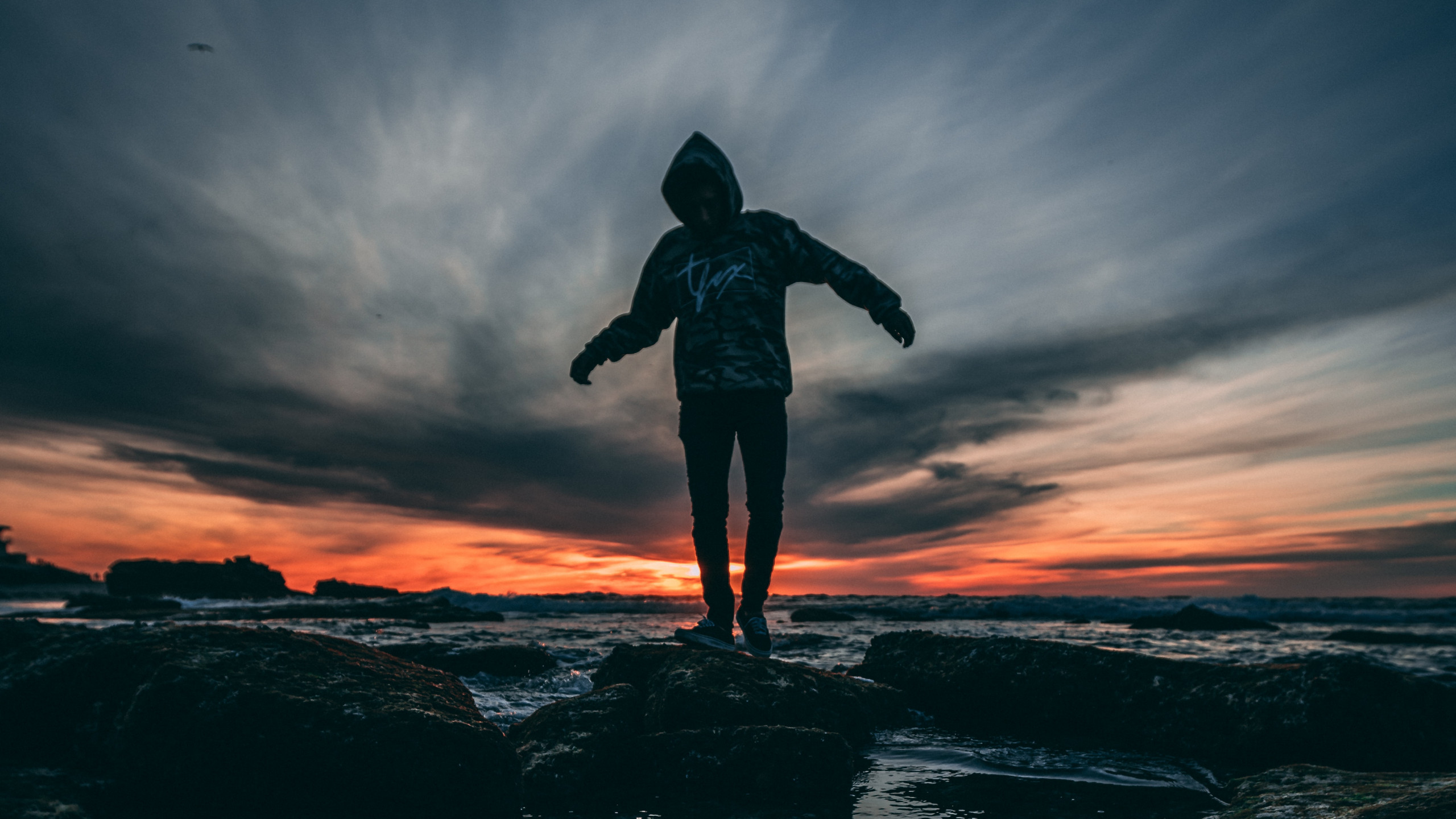 Person Wearing Hoodie Standing on Rock