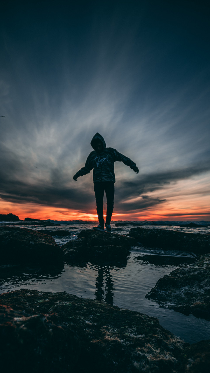 Person Wearing Hoodie Standing on Rock