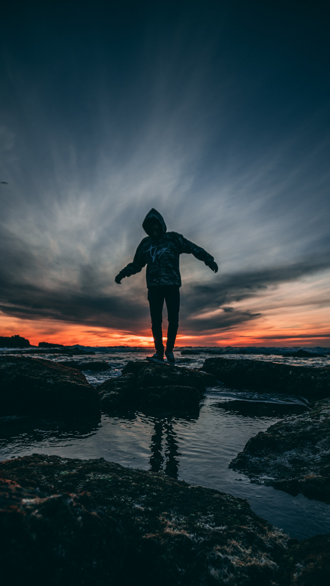 Person Wearing Hoodie Standing on Rock