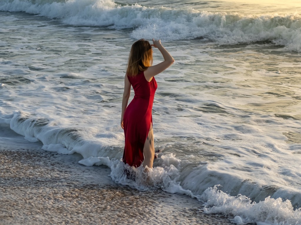Woman in Red Dress Standing on Beach