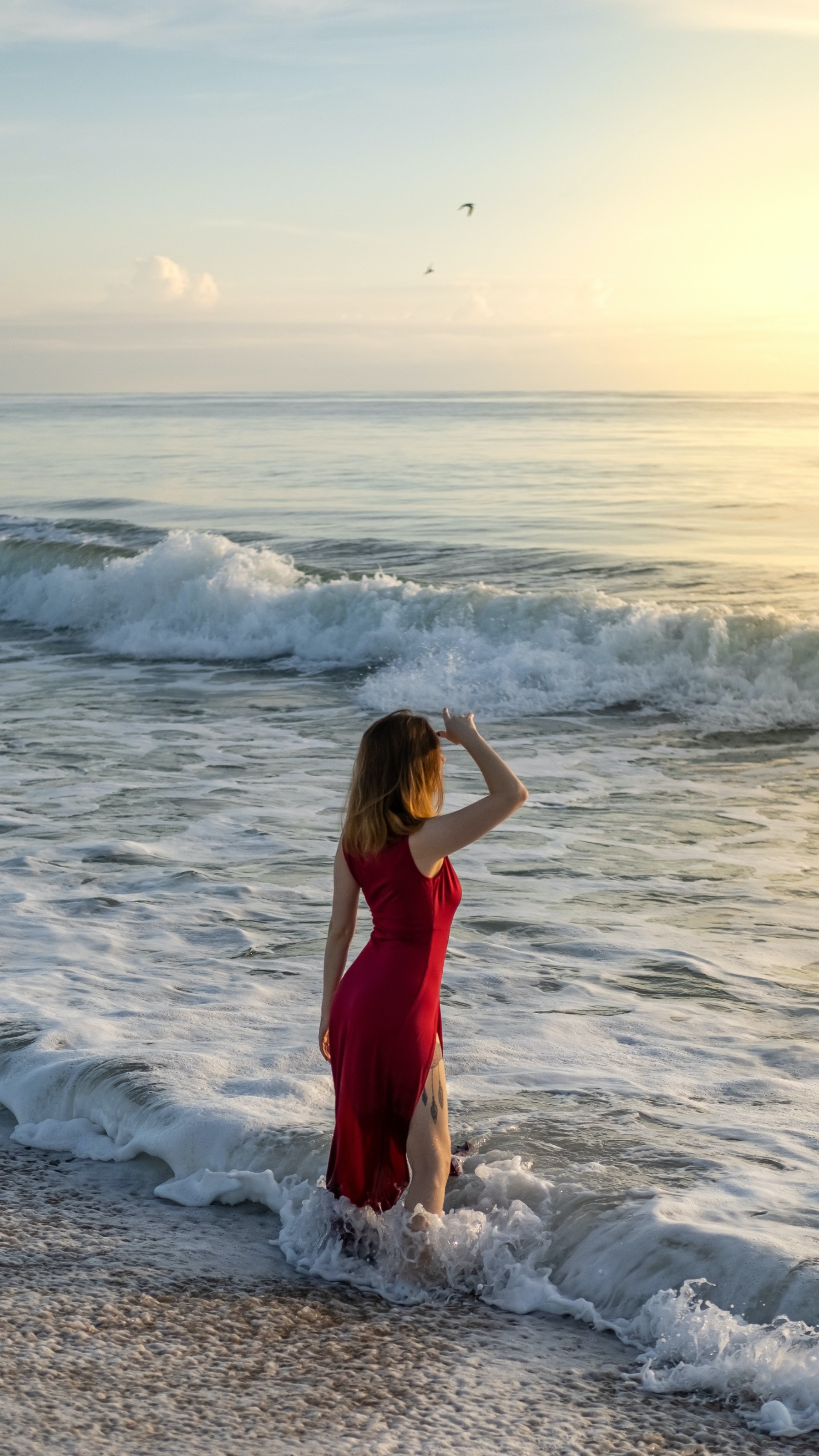Woman in Red Dress Standing on Beach