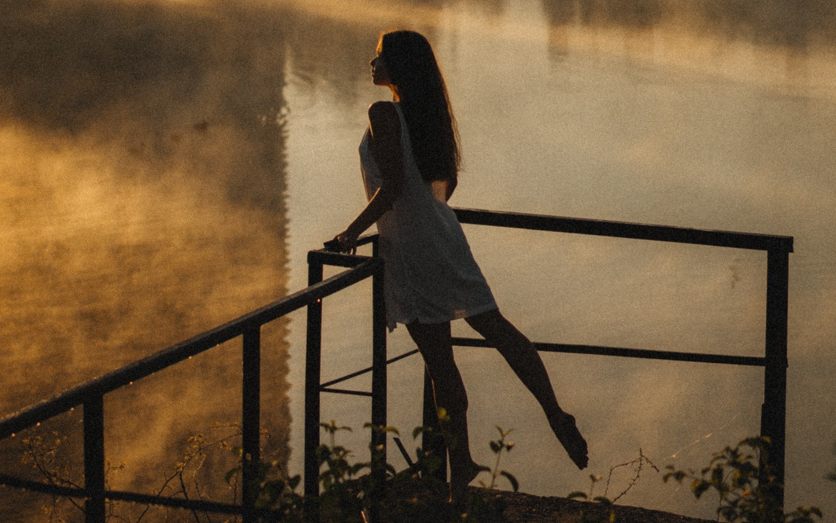 Woman Leaning against Railing By a Pond