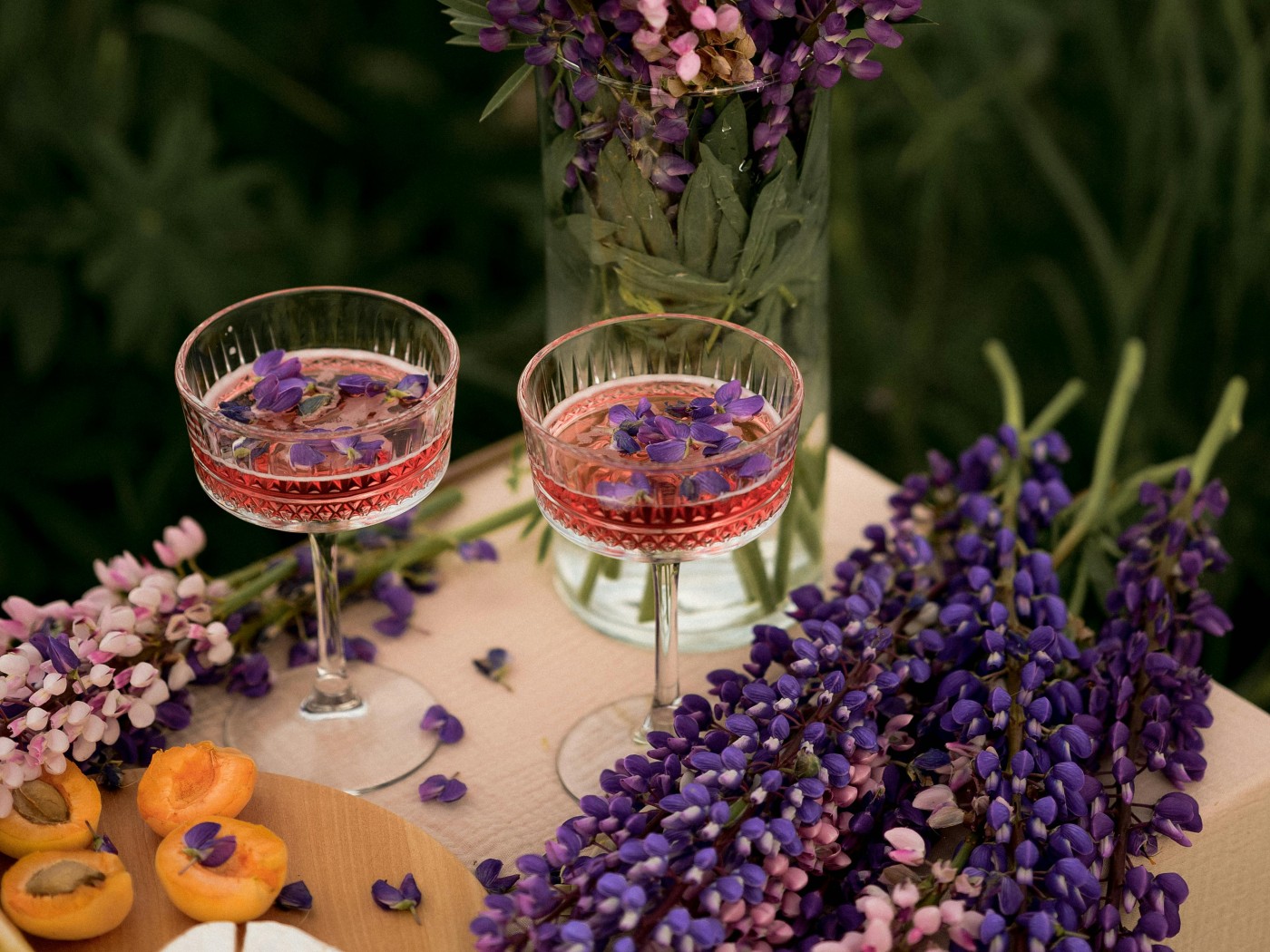 Purple Garden Lupin Flowers in Vase and Glasses of Drink