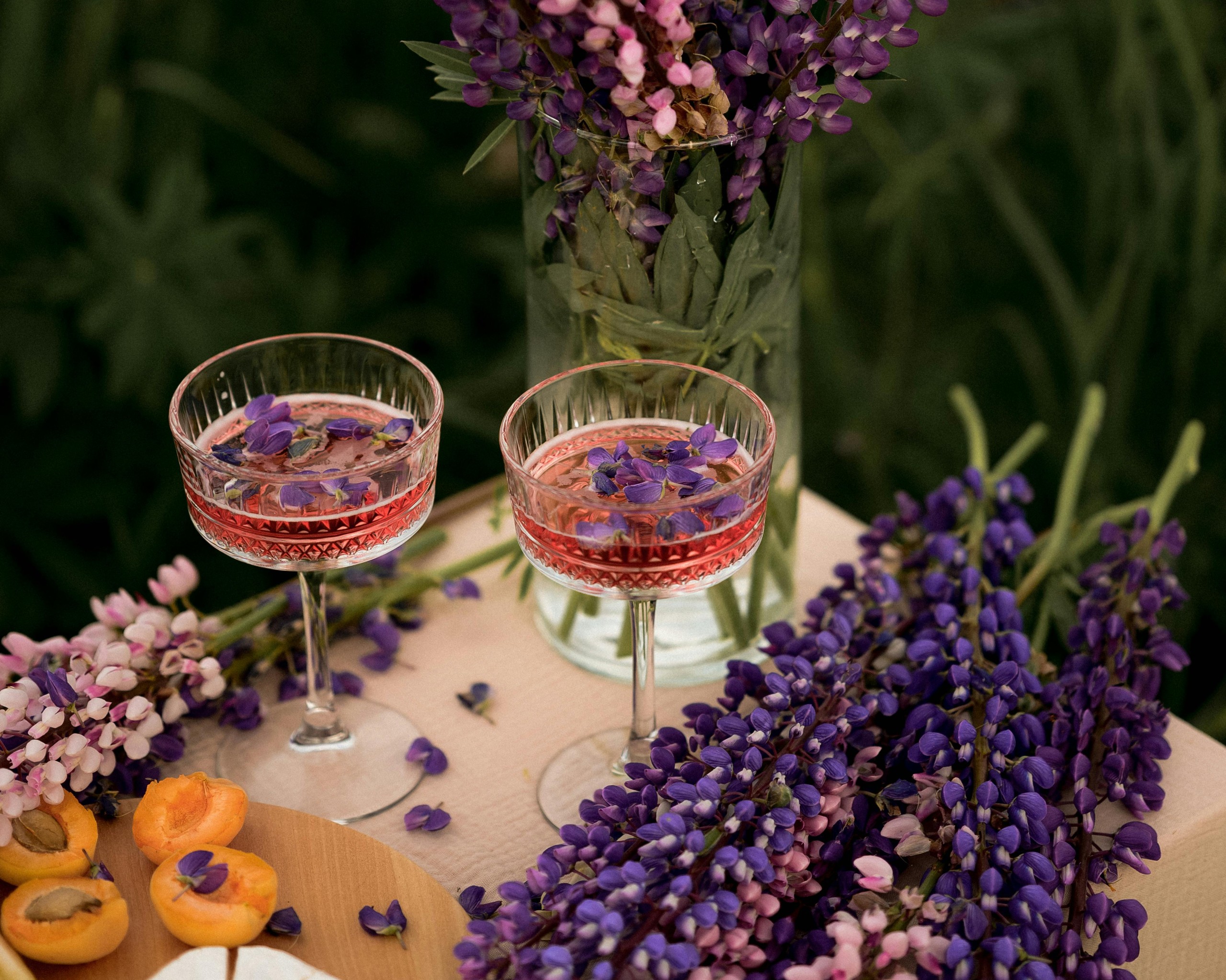 Purple Garden Lupin Flowers in Vase and Glasses of Drink